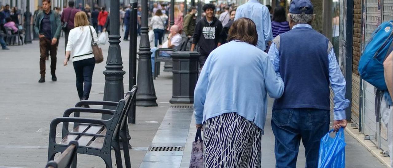 Una pareja de persona mayores pasea por una calle de Canarias.