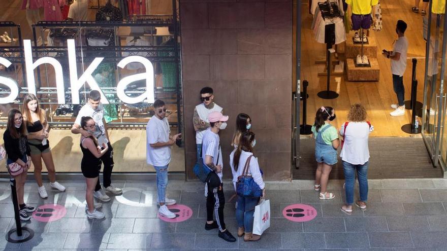 Gent fent cua per entrar a una botiga, aquest dissabte, a La Maquinista, a Barcelona