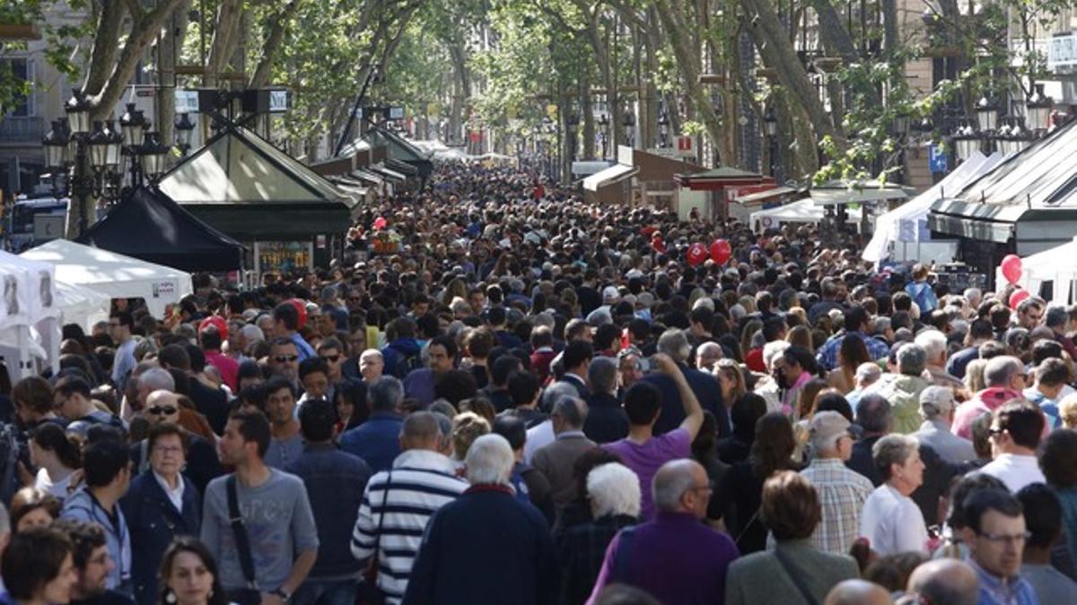 Cientos de personas visitan la Rambla de Catalunya, en la diada de Sant Jordi.