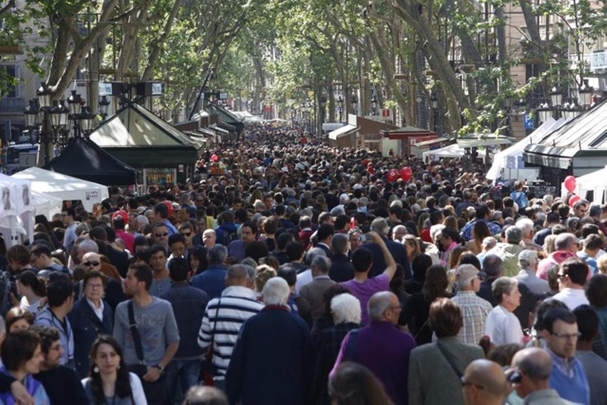 Cientos de personas visitan la Rambla de Catalunya, en la diada de Sant Jordi.