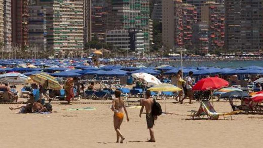 Turistas en la playa de Levante de Benidorm, al mediodía de ayer.