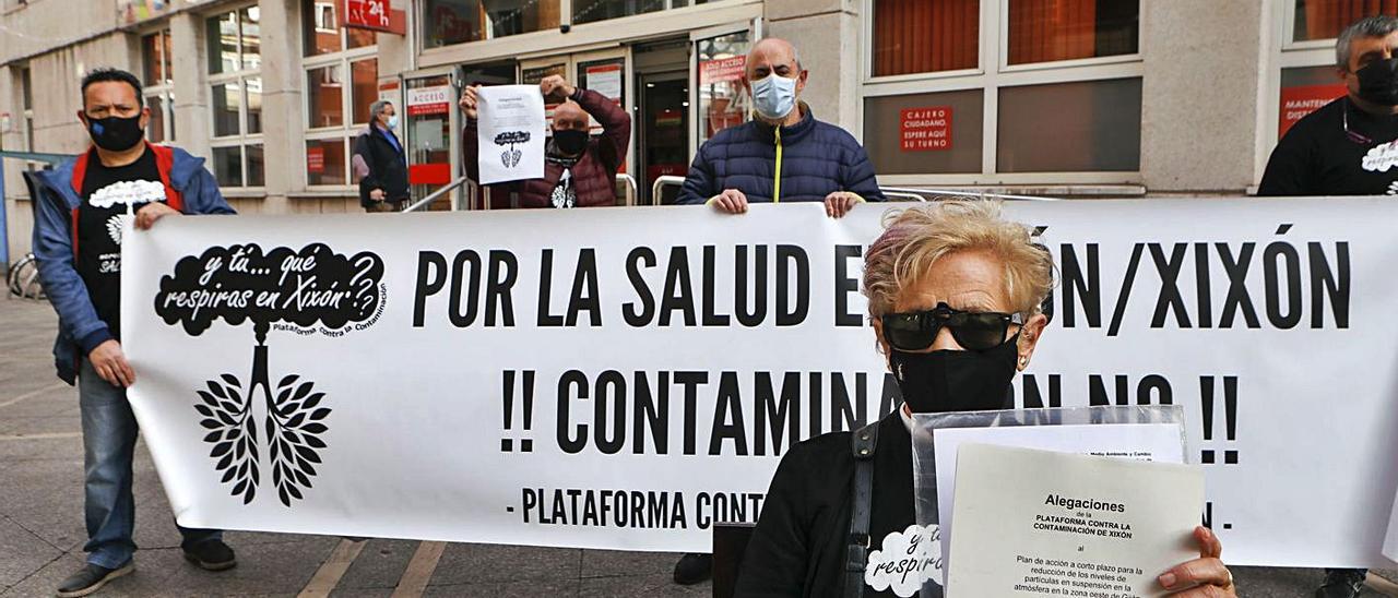 Angelita Menéndez sostiene las alegaciones de la Plataforma Contra la Contaminación. Tras ella, por la izquierda, José Emilio Martínez García, Luis Alfredo Hernández Fernández, José Luis Rodríguez Peón y José Luis Fernández Bernardo, que acudieron acompañados por Inés Prada al Ateneo Obrero de La Calzada. | Marcos León