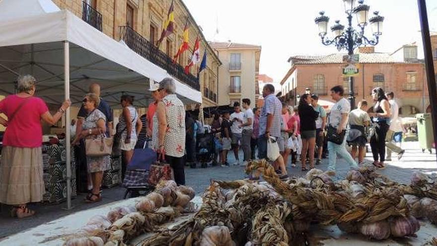 Asistentes al mercado de la verdura. En primer término, varias ristras de ajos.