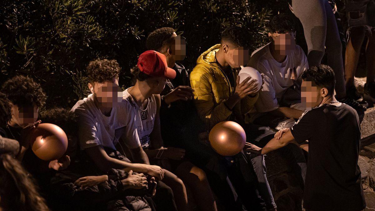 Imagen de archivo de varios jóvenes inhalando oxido nitroso con globos.