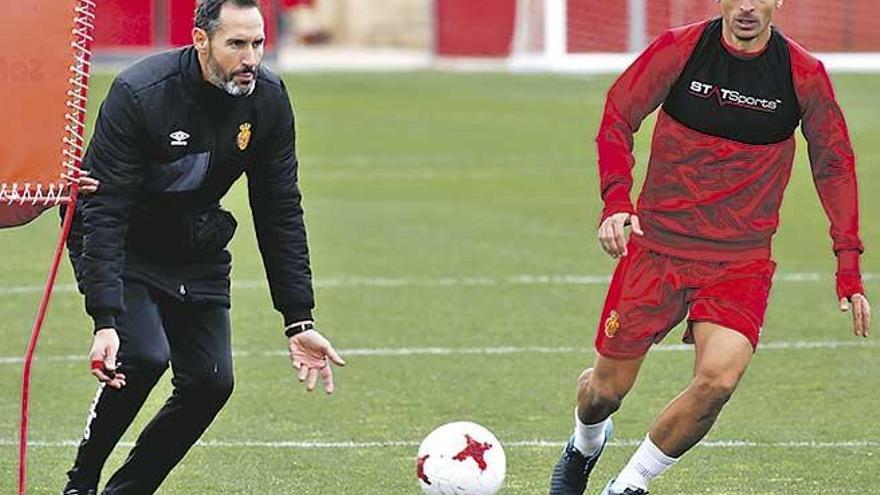 Vicente Moreno da instrucciones a sus jugadores ante la atenta mirada de Salva Sevilla.