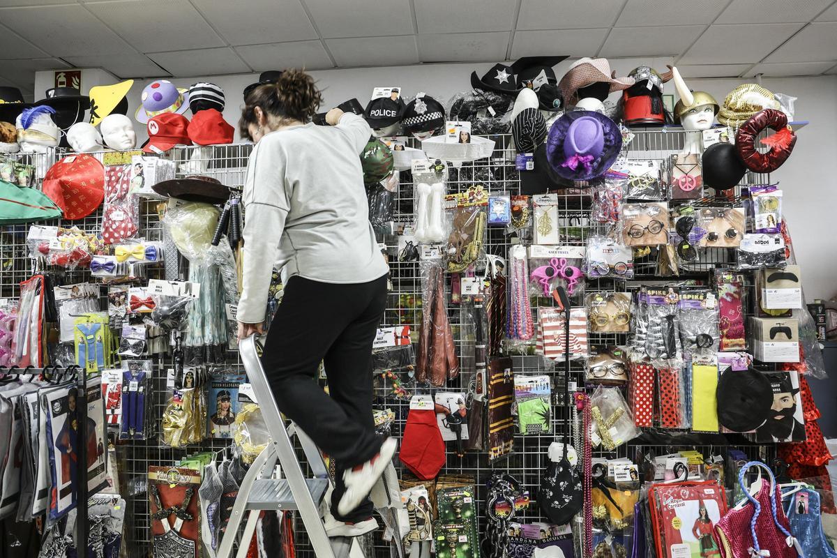 Una mujer coloca varios complementos en su tienda.
