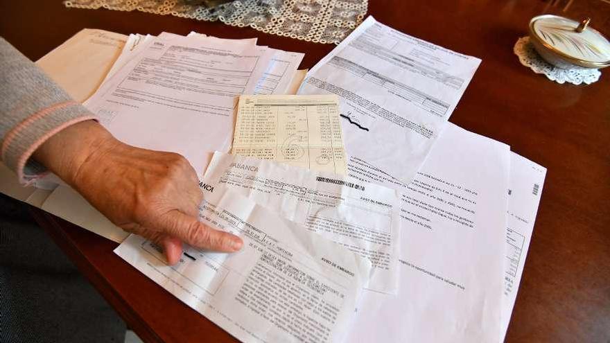 La pensionista mostrando los documentos de embargo y las cartas que envió al dueño del local. // G. Santos