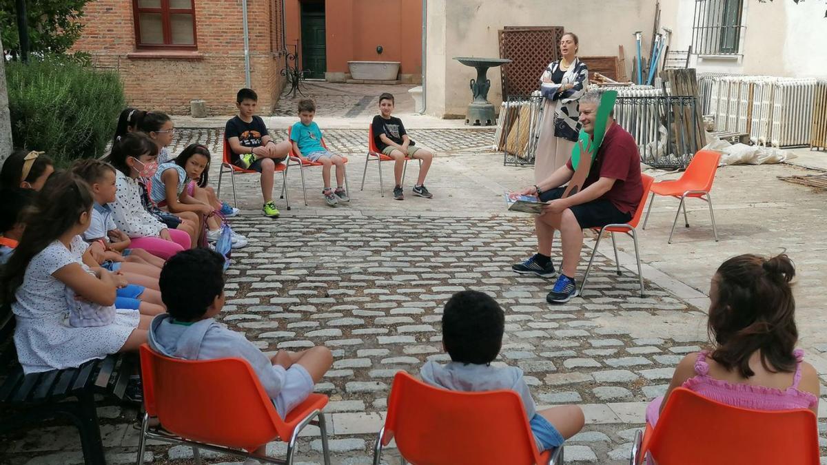 Niños disfrutan del relato de un cuento sobre los bosques en el jardín de la Casa de Cultura. | M. J. C.