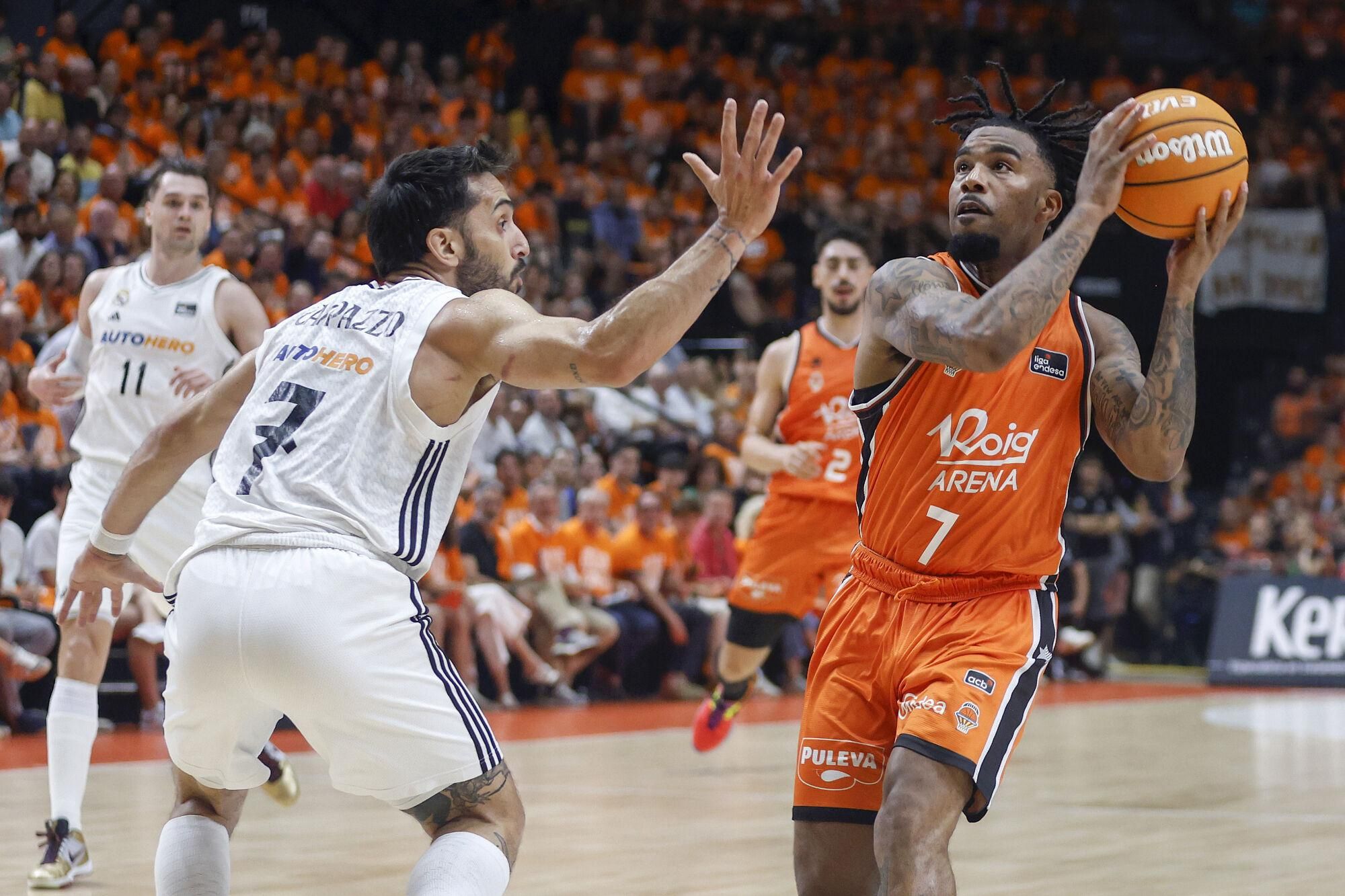 VALENCIA, 25/06/2025. El base estadounidense de Valencia Basket, Chris Jones (d), con el balón ante el base argentino del Real Madrid, Facundo Campazzo, durante el tercer partido de la final de la Liga Endesa que disputan hoy miércoles en el pabellón de la Fuente San Luis de Valencia. EFE/Miguel Ángel Polo.