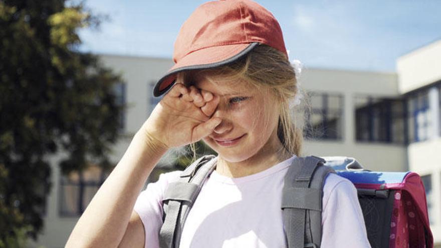 Una niña llora antes de entrar al colegio.