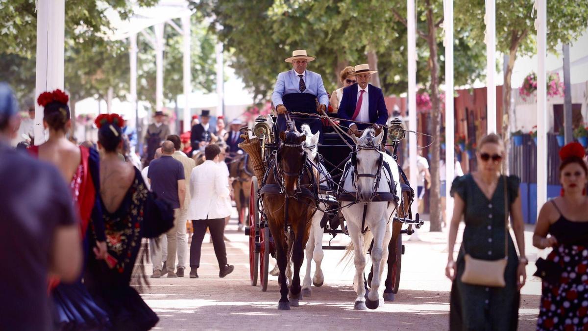Una multitud de personas pasea andando bajo caballo este sábado, por el recinto de la Feria de Córdoba.