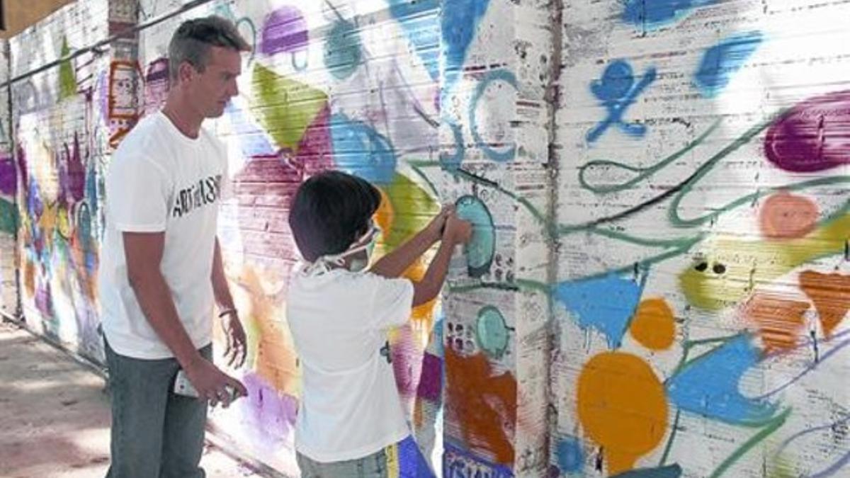 Paredes para todos 8 Un niño pinta una pared en un taller sobre arte mural en la calle de Marroc.