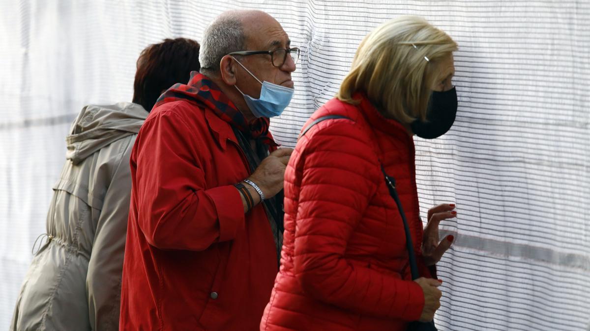 Gente mirando un espectáculo del Pilar a través de la malla.