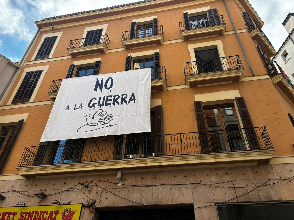 El PSOE ha desplegado una lona en la fachada de su sede con el lema 'No a la guerra'.