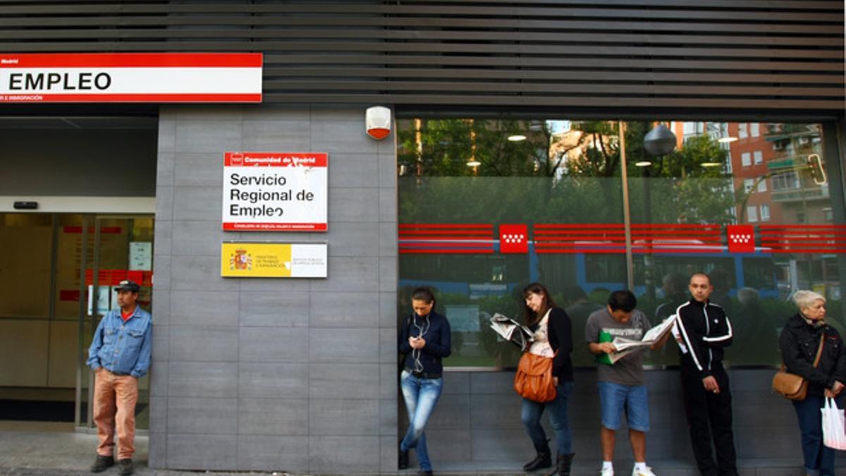 Un grupo de ciudadanos esperan a las puertas de una oficina de empleo en Madrid, el pasado abril.