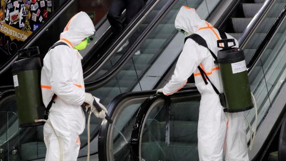 Trabajadores desinfectan unas escaleras mecánicas