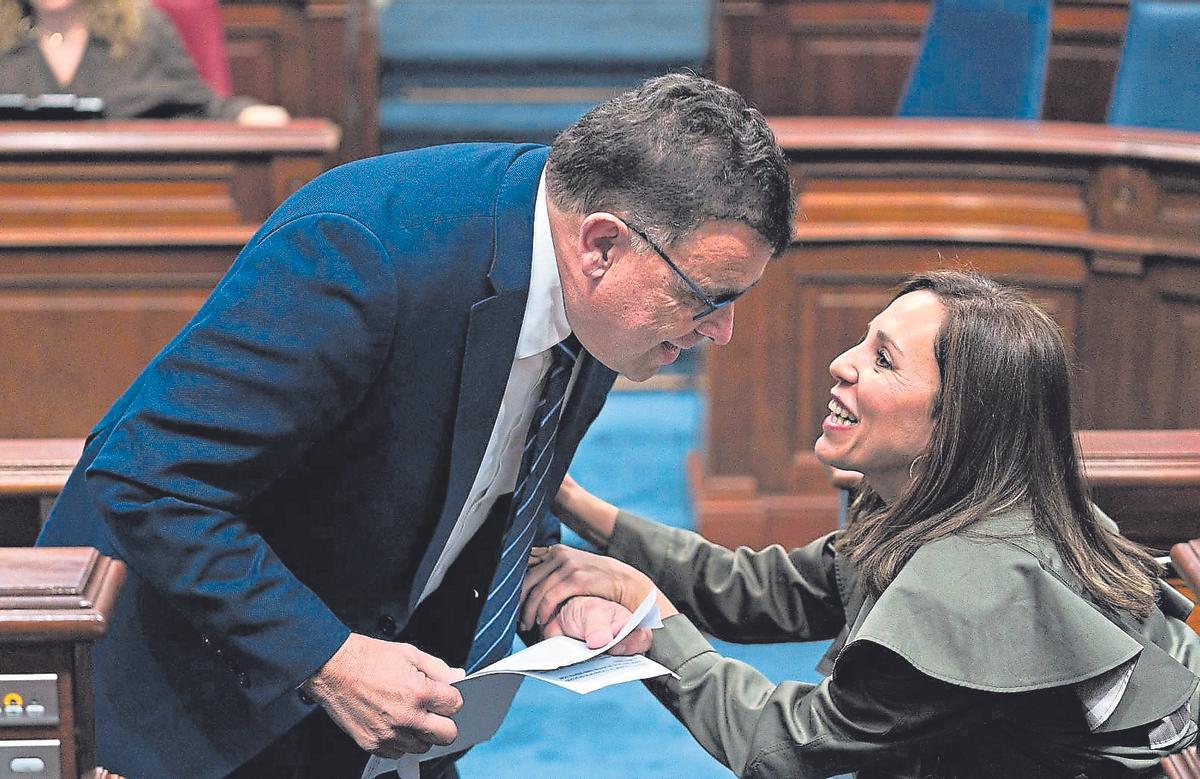 El consejero Manuel Miranda conversa, ayer, con la diputada socialista Patricia Hernández en el salón de plenos.