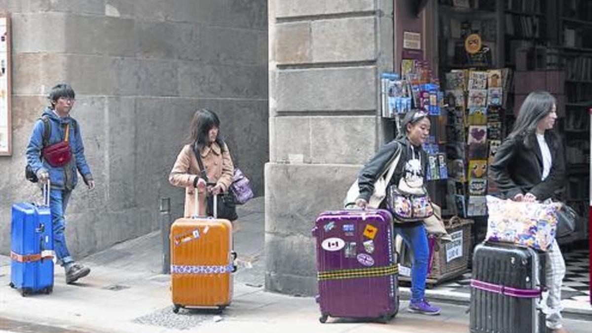 Cuatro turistas caminan con sus maletas por la calle de Jaume I, en el corazón de Ciutat Vella, el pasado marzo.