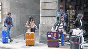 Cuatro turistas caminan con sus maletas por la calle de Jaume I, en el corazón de Ciutat Vella, en una imagen de archivo.