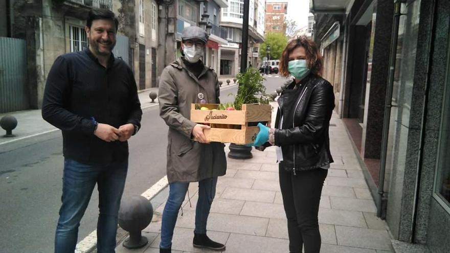 El ganador y la organizadora del concurso Santas Tapas Sanas, entregándole la cesta de productos de huerta a la representante de Cáritas.