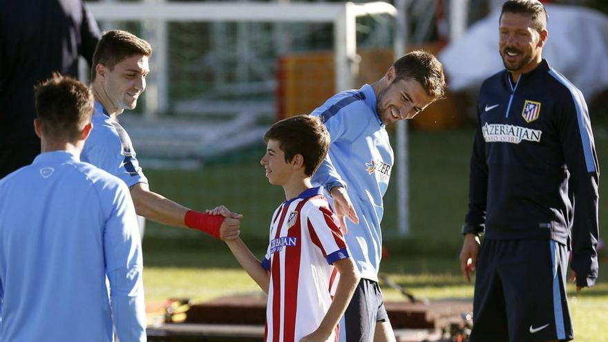 Diego Hernández saluda a un jugador mientras que Gabi y Simeone observan su camiseta.