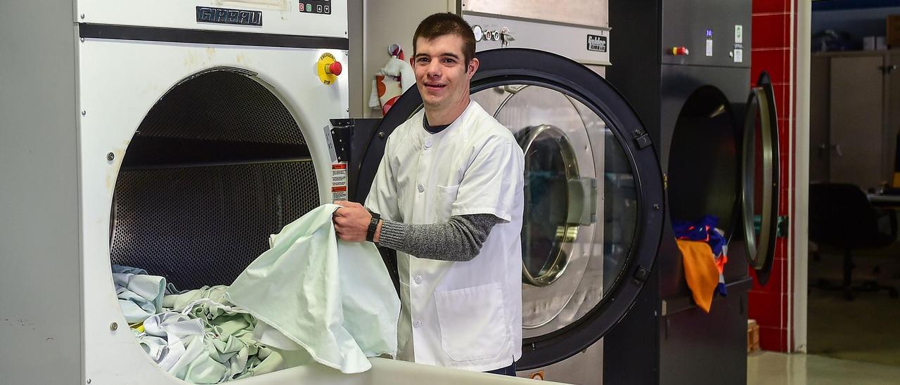 Raúl Lozano, con síndrome de Down, en la lavandería del hospital de Plasencia.