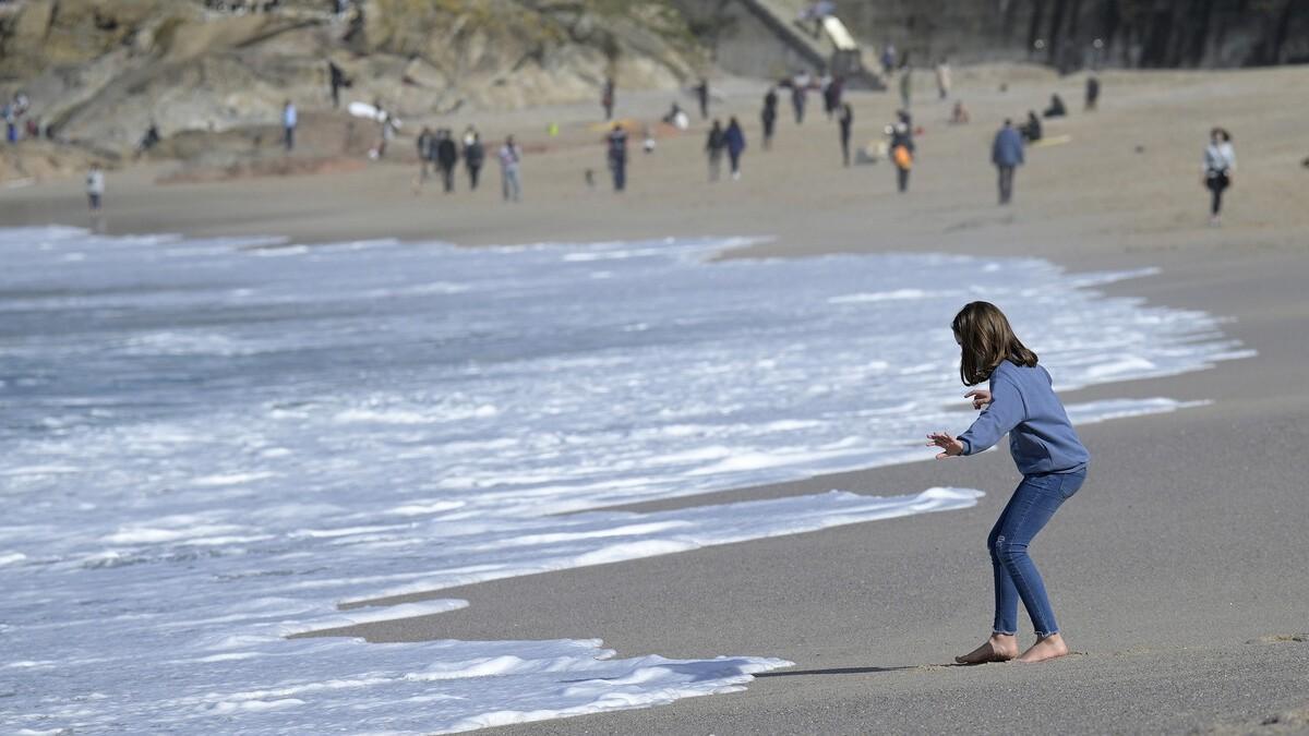 Una niña se acerca a la orilla en la playa del Orzán, en A Coruña, durante una de las jornadas primaverales de este semana