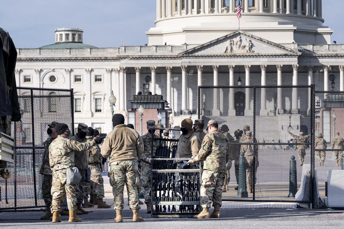 Soldados de la Guardia Nacional transportan fusiles de combate para garantizar la seguridad en el Capitolio antes del ’impeachment’ a Trump
