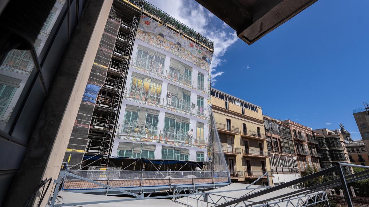 Una lona cubre la fachada posterior de la Casa Batlló y muestra, de paso, cuál será el resultado final de la restauración.