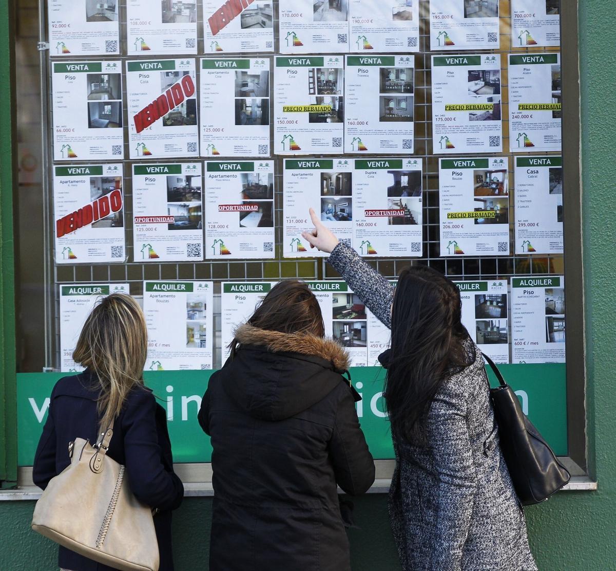 Jóvenes en un escaparate de una inmobiliaria
