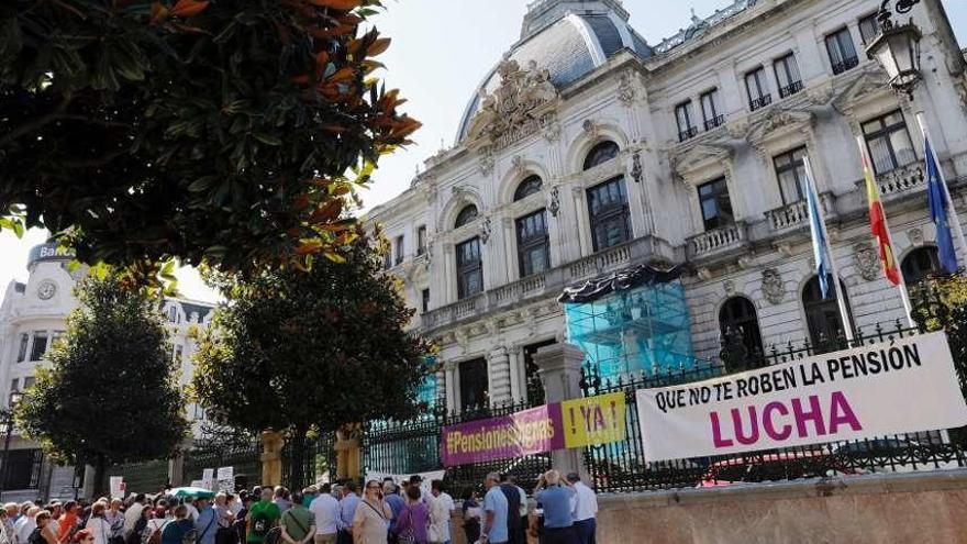 Manifestantes y pancartas, ante la sede de la Junta General del Principado, en Oviedo.