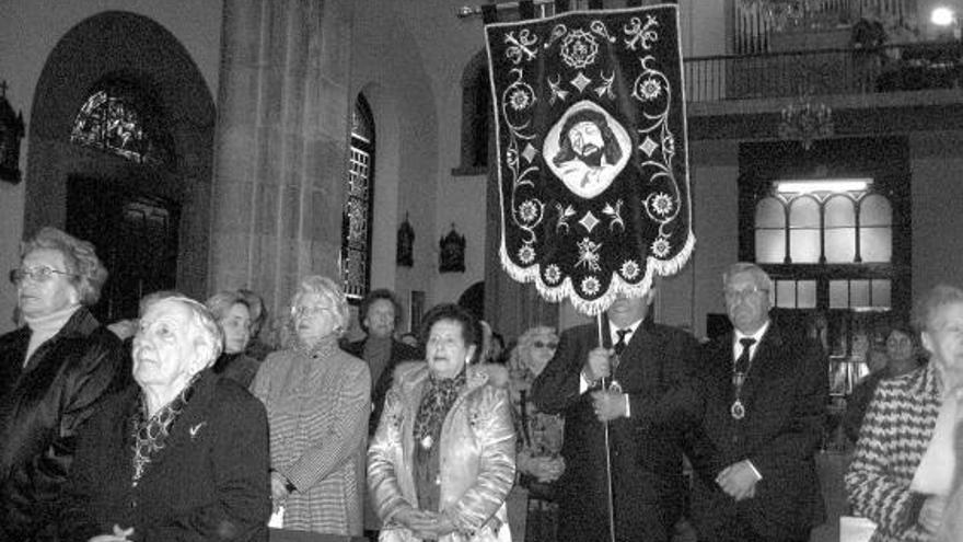 Un cofrade porta el estandarte junto a Roberto Rodríguez, hermano mayor de la cofradía moscona, ayer, en Grado.