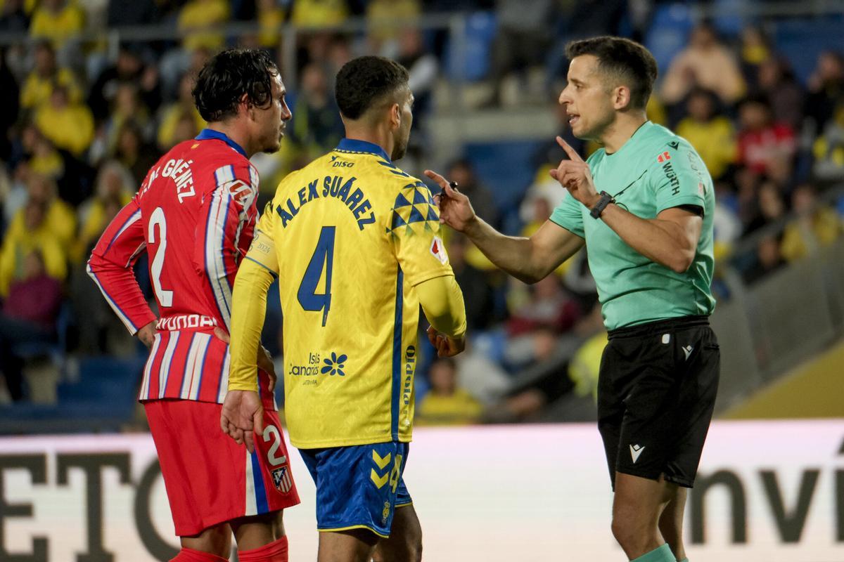 El árbitro Víctor García Verdura conversa con los capitanes del Atlético de Madrid, José María Giménez, y el del Las Palmas, Álex Suárez durante el partido de la jornada 32 de la Liga 2024-25.