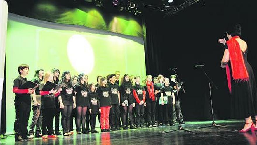 Arriba, el coro infantil de la Escuela de Música, durante su intervención. Sobre estas lineas, un momento de la entrega de premios a los escolares ganadores del concurso de poesía.