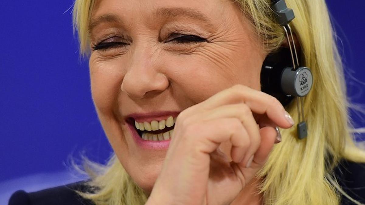 La líder del FN francés, Marine Le Pen, sonríe en una conferencia en Bruselas.