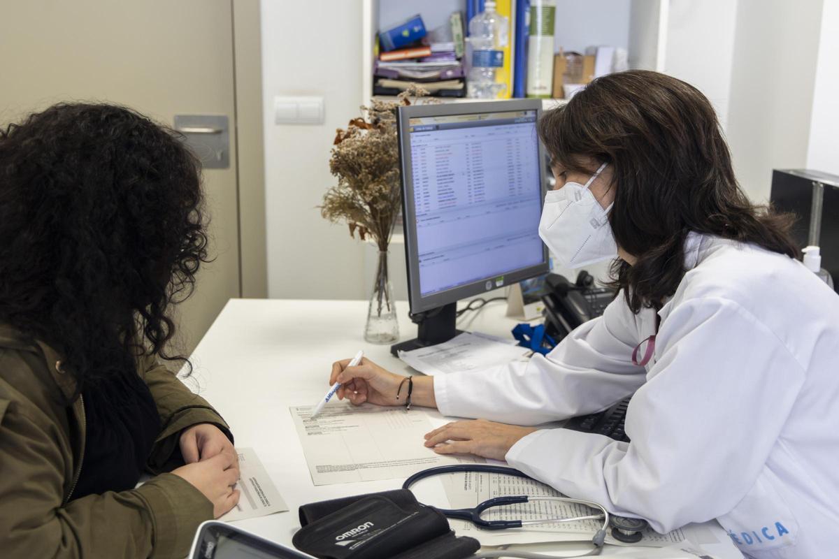 Una médica atiende a una paciente.