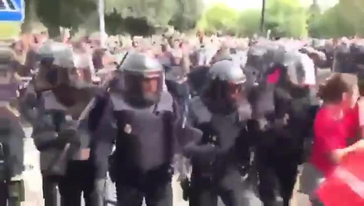 La Policia Nacional carrega contra un cordó de seguretat realitzat per efectius del cos de Bombers de la Generalitat davant un col·legi electoral.