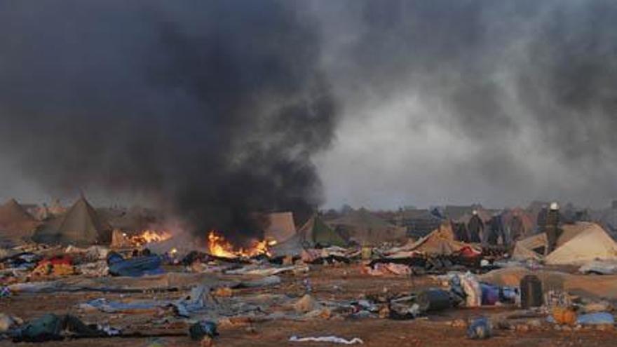 Soldados registran el campamento de Agdayim Izik, en el Sáhara Occidental, con las tiendas en llamas