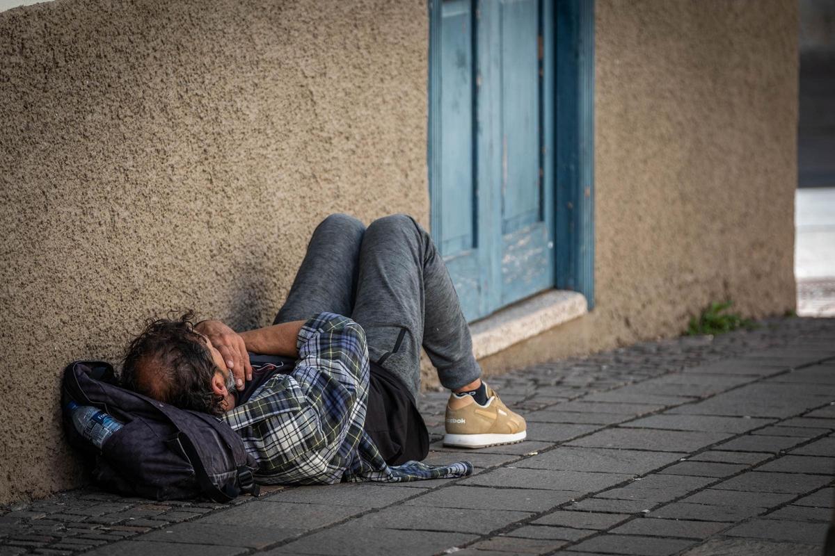 Un hombre descansa en el suelo de una calle de Santa Cruz de Tenerife.