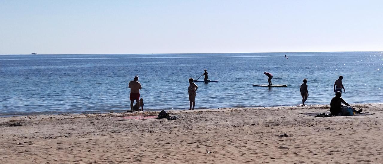 Els banyistes practiquen el &#039;paddle surf&#039; a la platja de la Marineta Cassiana de Dénia