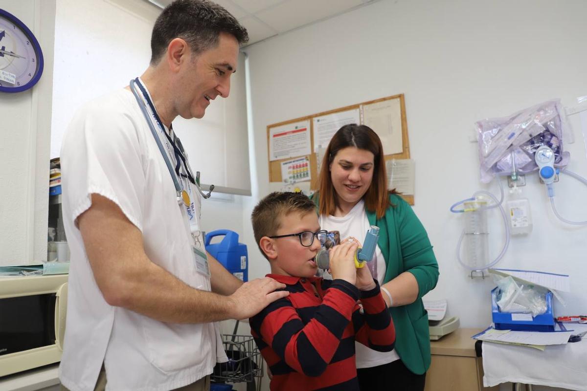 El doctor Javier Torres, con un paciente pediátrico que padece alergia respiratoria, y su madre, en el hospital Reina Sofía.