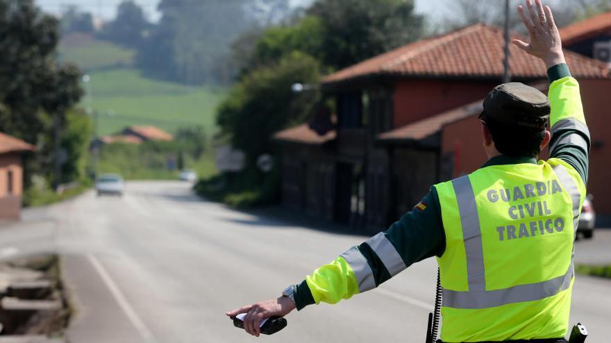 Un agente hace la señal a un vehículo para que se detenga por circular a velocidad inadecuada.