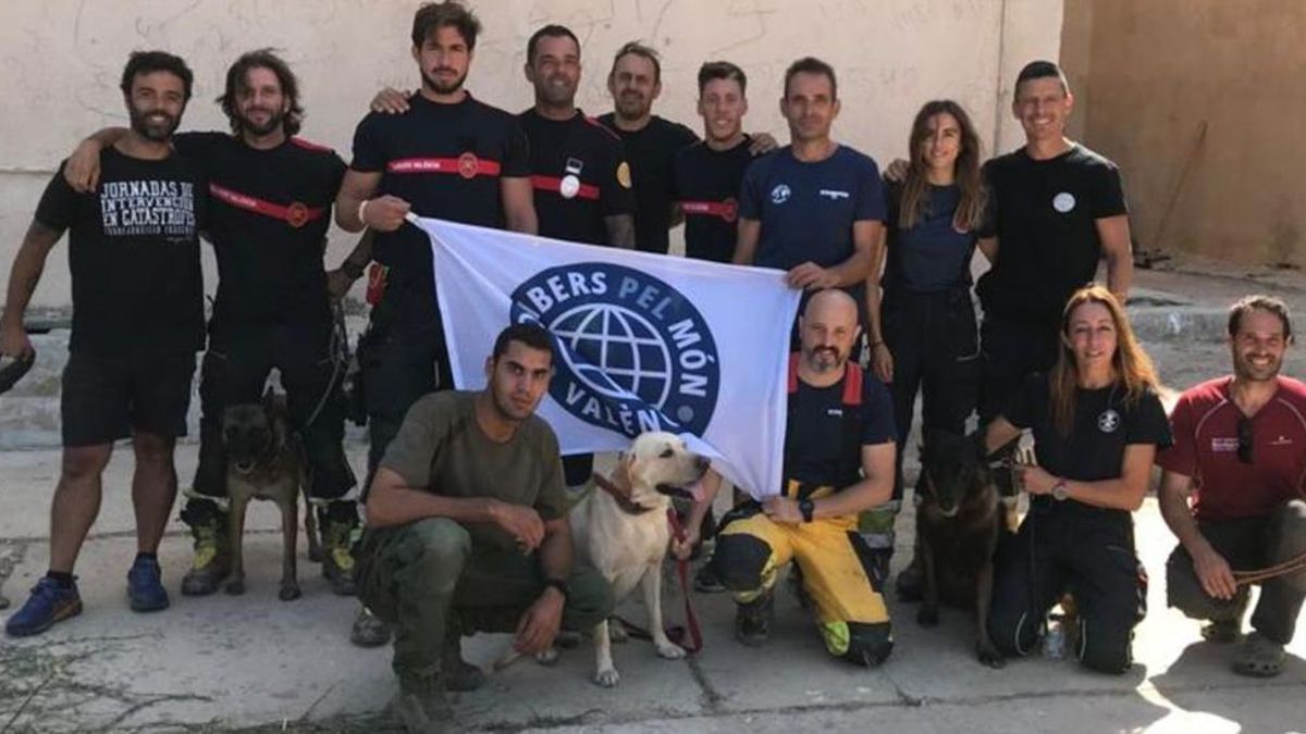 Foto de grupo de los 11 bomberos y los 3 perros buscapersonas de Bombers pel Món de Valencia.