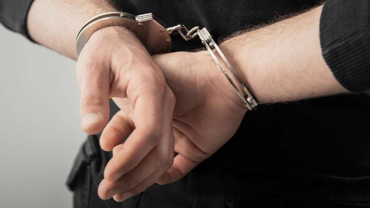 Una mujer esposada tras una detención.