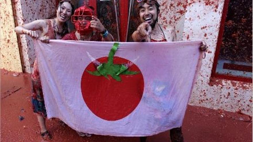 Tres jóvenes japoneses disfrutaron de la fiesta e improvisaron una bandera &quot;nipona&quot;
