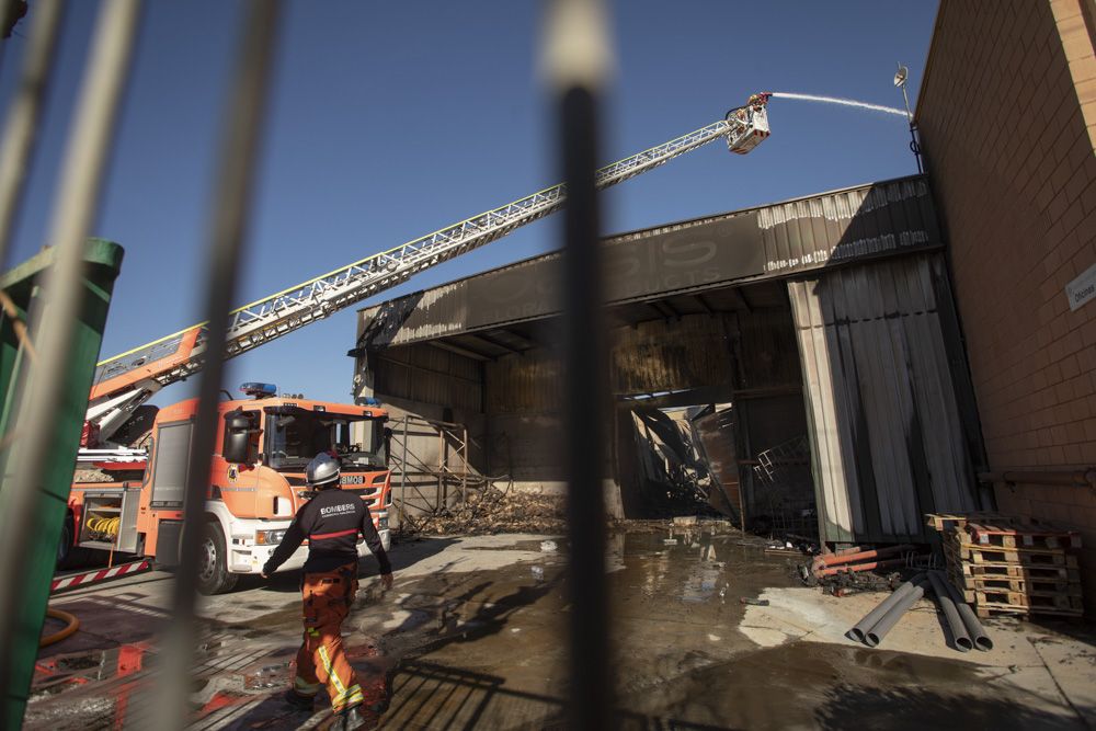 Los bomberos siguen trabajando en la nave del Port de Sagunt un día después del incendio