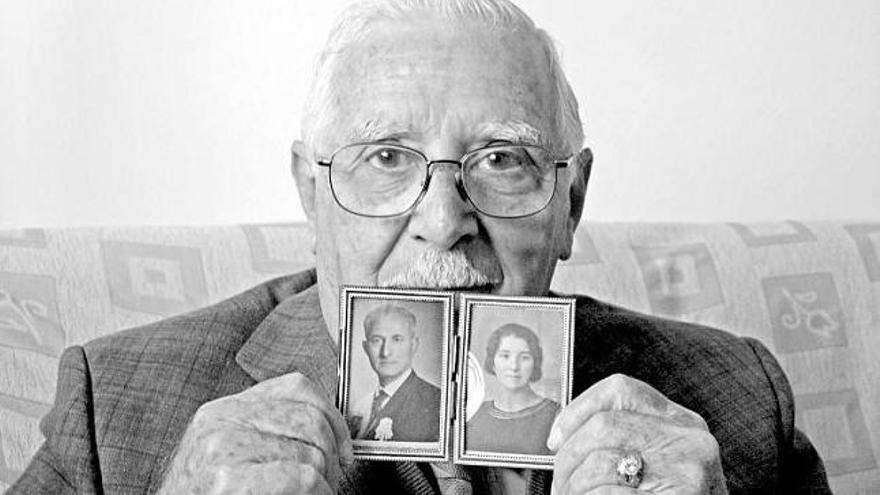 Pedro Fernández Rosón sostiene las fotos de sus padres, en su domicilio de Gijón.