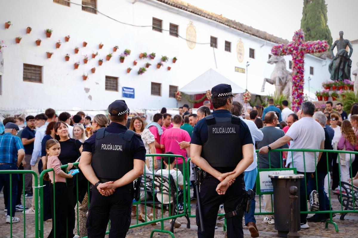 Dos agentes de la Policía Local vigilan el ambiente de cruces en la Cruz de Mayo Hermandad del Resucitado.