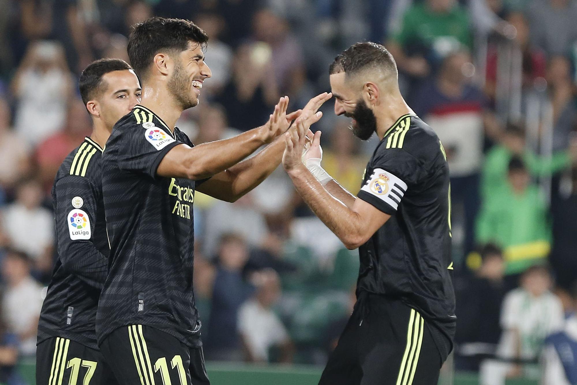 Marco Asensio y Karim Benzema se abrazan durante un partido del Real Madrid.