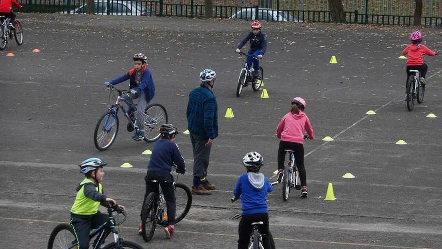 Varios alumnos, ayer, aprendiendo a andar en bici en el patio del colegio Enrique Alonso.